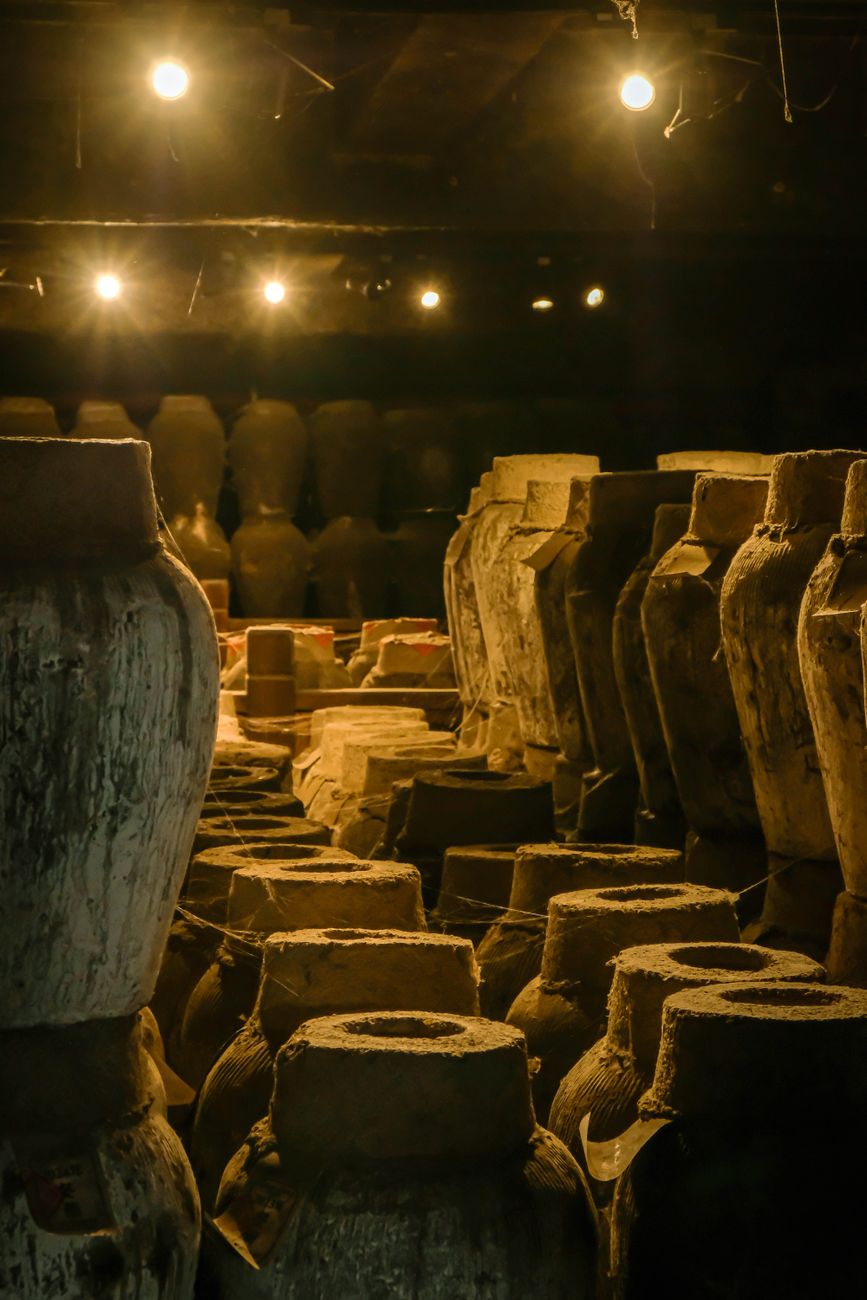 Terracotta amphora vessels inside a rustic cellar